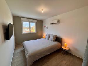 a bedroom with a bed and a window and two lamps at maison 24 couchages in Clermont-Créans