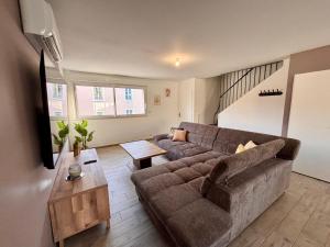 a living room with a couch and a table at maison 24 couchages in Clermont-Créans