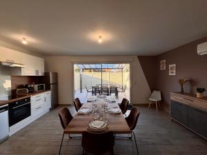 a kitchen with a long table with chairs in it at maison 24 couchages in Clermont-Créans