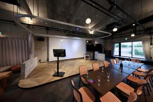a conference room with a table and chairs and a screen at クリスタルヴィラ大浦 in Miyako-jima