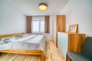 a bedroom with a bed and a dresser at Vila SIGORD in Kokošovce