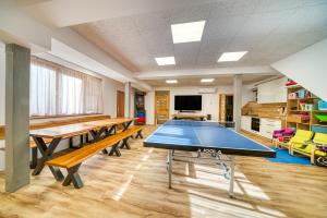 a classroom with a ping pong table in a room at Vila SIGORD in Kokošovce