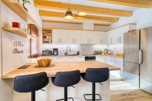 a kitchen with white cabinets and a wooden counter top at Vila SIGORD in Kokošovce