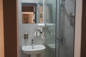 a bathroom with a sink and a shower with a mirror at NINETY boutique hotel in Yakkasaray +34 photos