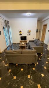 ein Wohnzimmer mit zwei Sofas und einem Tisch in der Unterkunft Pasithea's Apartment in Samos