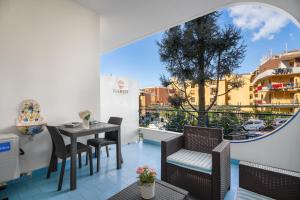 a balcony with a table and chairs and a window at The Reef Sorrento in Sorrento