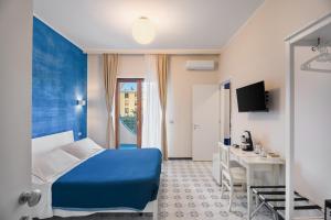 a hotel room with a blue bed and a desk at The Reef Sorrento in Sorrento