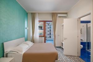 a hotel room with a bed and a bathroom at The Reef Sorrento in Sorrento