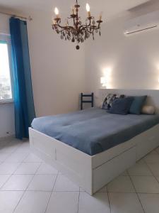 a bedroom with a large bed with a chandelier at Casa AnnaMarea in San Vincenzo
