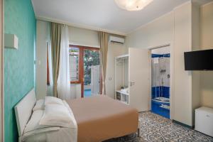 a bedroom with a bed and a tv and a bathroom at The Reef Sorrento in Sorrento +37 photos