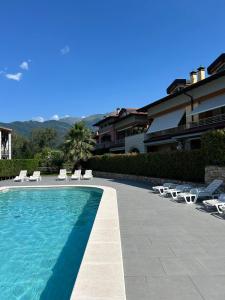 a swimming pool with lounge chairs and a swimming pool at Residence Lario Village in Colico