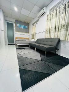 a waiting room with a couch and a rug at Homestay 14 Tôn Đức Thắng in Phan Thiet