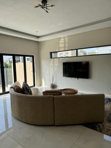 a living room with a couch and a flat screen tv at Eye with a view in Eikenhof
