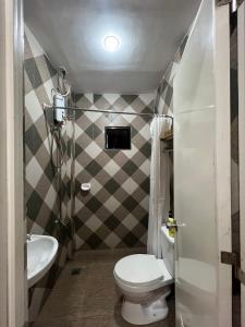 a small bathroom with a toilet and a sink at Sonora's Inn, Coron in Coron +34 photos