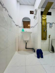 a white bathroom with a sink and a mirror at Homestay 14 Tôn Đức Thắng in Phan Thiet