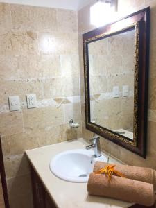 a bathroom with a sink and a large mirror at Las Galeras Hotel in Las Galeras