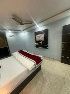 a bedroom with a bed and a flat screen tv at Hotel KS GRAND in Mandhana