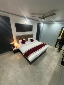 a bedroom with a large white bed with red pillows at Hotel KS GRAND in Mandhana +5 photos