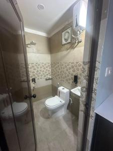 a bathroom with a toilet and a sink and a shower at Hotel KS GRAND in Mandhana