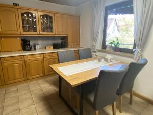 a kitchen with a wooden table and chairs and a window at Ferienwohnung am Breitenbach in Ebermannstadt +30 photos