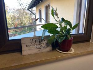 a plant sitting on a window sill next to a sign at Ferienwohnung am Breitenbach in Ebermannstadt