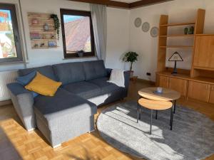 a living room with a blue couch and a table at Ferienwohnung am Breitenbach in Ebermannstadt
