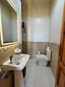 a white bathroom with a sink and a toilet at Ta Carmen Farmhouse with pool in Qala +31 photos