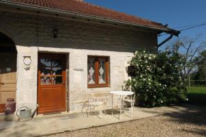 a building with a table and chairs outside of it at Che'Val d'Amour in Écleux
