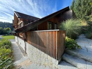 a wooden house with a fence on the side of it at In der Hollau - Your Austrian Home in Altaussee