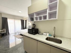 a kitchen with a sink and a bed in a room at West14 Tamarin Bay,Studio in Tamarin