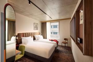a hotel room with two beds and a window at You Hotel Amiens - Handwritten Collection in Amiens +106 photos