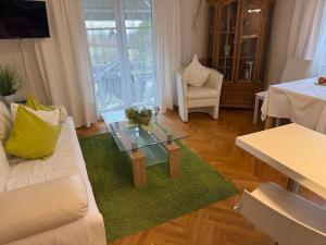 ein Wohnzimmer mit Sofa und Glastisch in der Unterkunft MarijaM-Haus in Badenweiler