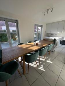 a kitchen with a long wooden table and chairs at Seaward Cottage met Jacuzzi in De Haan