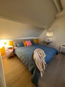 a bedroom with a large bed in a attic at Seaward Cottage met Jacuzzi in De Haan