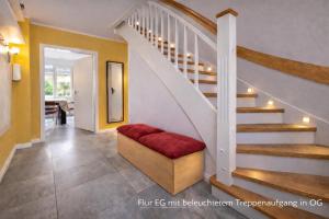 a living room with a staircase with a red seat at Villa Mara - für 12 Gäste, Sauna, 1 Wirlwanne, 2 Duschen, Kamin, 5 SZ, 3 WC, Highspeed Internet, abgezeuntes Grundstück in Glowe