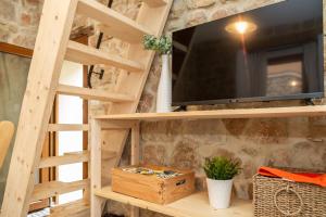 a living room with a tv and a wooden shelf at Climbing House in Baunei