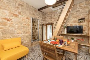 a living room with a table and a yellow chair at Climbing House in Baunei