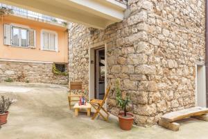 a stone building with a chair and a stone wall at Climbing House in Baunei