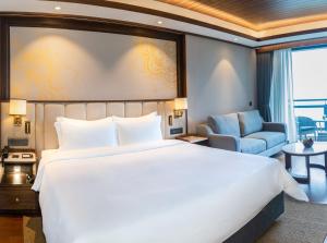 a hotel room with a large bed and a chair at Dusit Thani Himalayan Resort Dhulikhel, Nepal in Dhulikhel
