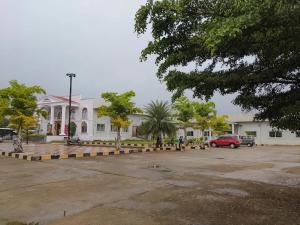 a parking lot in front of a white building at Sanctuary by JVS Palace in Hindupur