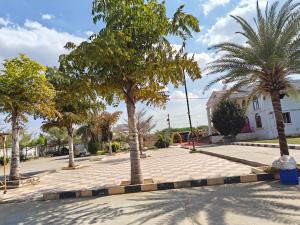 a street with palm trees and a playground at Sanctuary by JVS Palace in Hindupur +3 photos