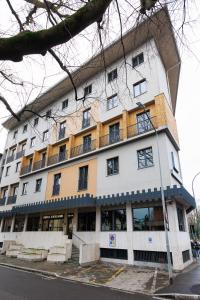 a large white building with a balcony on a street at Hotel Excelsior Magenta in Magenta