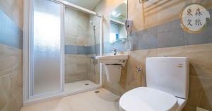 a bathroom with a toilet and a shower and a sink at 享受一下民宿-免費停車-寵物友善-無門禁24小時進出-東森文旅-包棟優惠中 in Chung-ho +14 photos