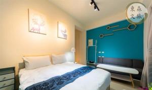 a bedroom with a bed and a blue wall at 享受一下民宿-免費停車-寵物友善-無門禁24小時進出-東森文旅-包棟優惠中 in Chung-ho