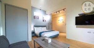 a hotel room with a bed and a tv at 享受一下民宿-免費停車-寵物友善-無門禁24小時進出-東森文旅-包棟優惠中 in Chung-ho