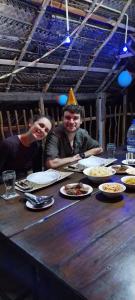 a man and a woman sitting at a table with food at Mango Mango in Tangalle