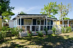 a blue tiny house with a porch at Club del Sole Marina Family Resort in Punta Marina