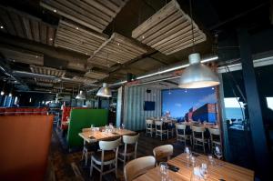 a restaurant with wooden tables and chairs and a large window at Riotel Matane in Matane