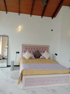 a bedroom with a large bed with a pink headboard at Mulberry villa in Kandy +28 photos