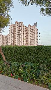 a large apartment complex with tall buildings in the background at Anandam in Vrindāvan
